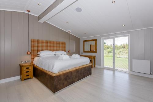 a bedroom with a large bed and a large window at Landal North Lakes in Brayton Station