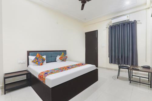 um quarto com uma cama e uma escrivaninha em FabHotel JP International em Lucknow