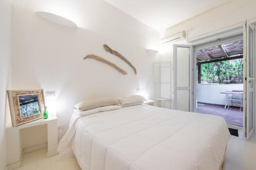 une chambre blanche avec un grand lit et une table dans l'établissement Villa Amaranta - Is Molas, à Is Molas 