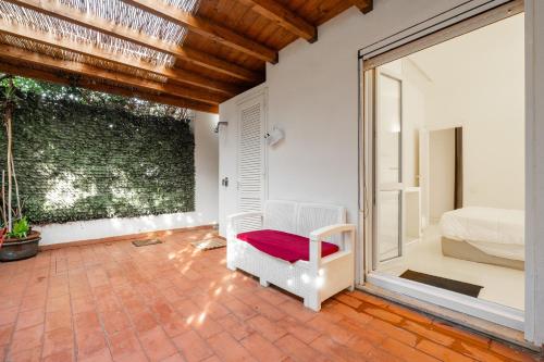 Cette chambre comprend un lit, une chaise et une fenêtre. dans l'établissement Villa Amaranta - Is Molas, à Is Molas 