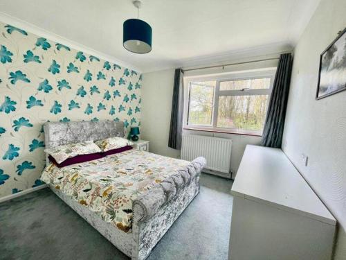 ein Schlafzimmer mit einem Bett und einem Fenster in der Unterkunft Family-Game room-Sleeps 10-Parking-Pets-Bbq in Harlow