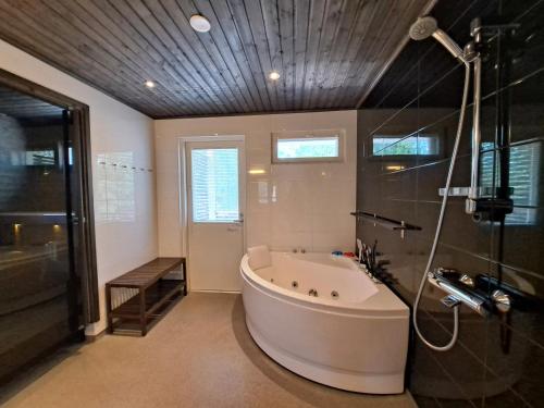 une grande salle de bain avec baignoire et douche dans l'établissement Särkänhelmi, à Kalajoki