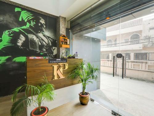 a lobby with two potted plants on a wall at Super Hotel O Centrum in Gorakhpur