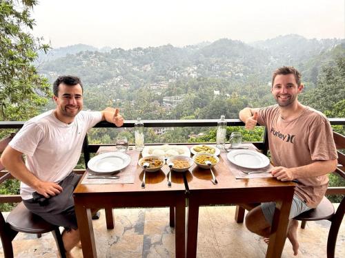 Twee mannen aan een tafel met eten erop. bij Bloom Hill Kandy in Kandy