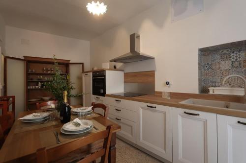 Una cocina con una mesa de madera y un comedor. en VicoloHOME, en Fragneto lʼAbate