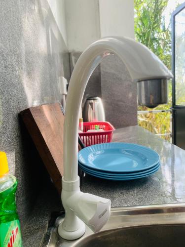 a kitchen sink with a white faucet next to a plate at Hidden Well Hiriketiya in Hiriketiya