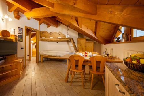 uma cozinha com uma mesa e cadeiras e uma cama em Agritur Bontempelli em Pellizzano