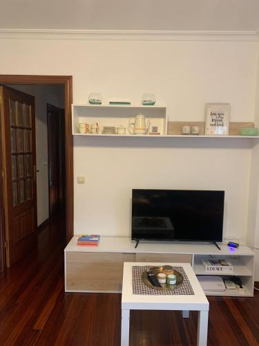 un soggiorno con TV e tavolino da caffè di O remanso de arcade a Arcade