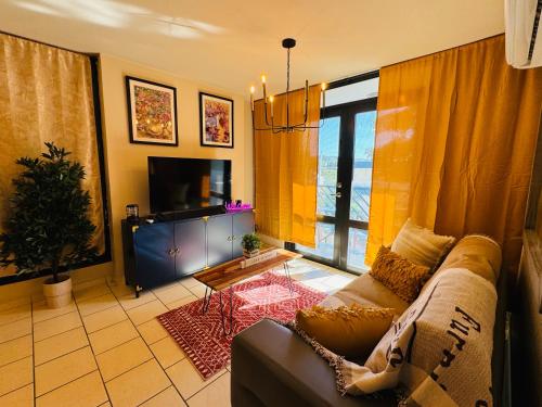 un salon avec un canapé et une télévision dans l'établissement Simple but pretty Nice location, à Yauco