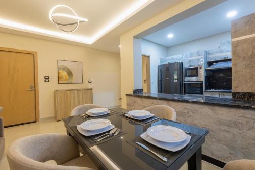een eetkamer met een tafel en stoelen en een keuken bij The D9 Luxury Suites - Hurghada in Hurghada