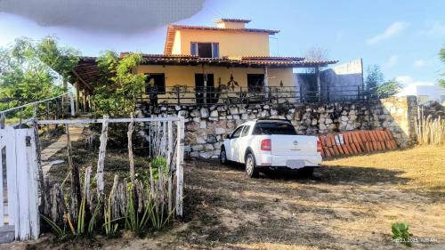 a white car parked in front of a house at Casa Nativa Coqueiro II in Luis Correia