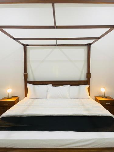 a bedroom with a large bed with two night stands at THE ONE Villa in Weligama