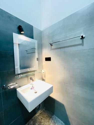 a bathroom with a white sink and a mirror at THE ONE Villa in Weligama