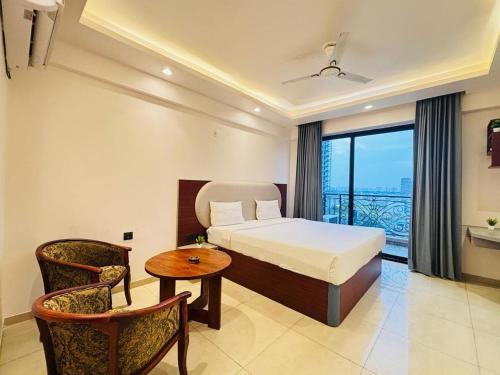 a hotel room with a bed and a table and chairs at Hotel Maple Tree , Gomtinagar Extension , Lucknow in Lucknow