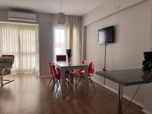 a dining room with a table and red chairs at Deka Evleri in Izmir