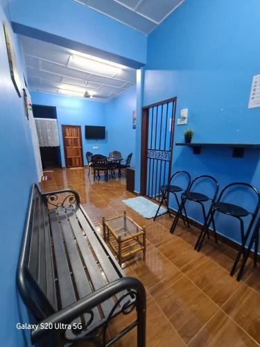 a blue room with a bench and tables and chairs at ShopLot Hostel Pangkor in Kampong Pasir Bogak