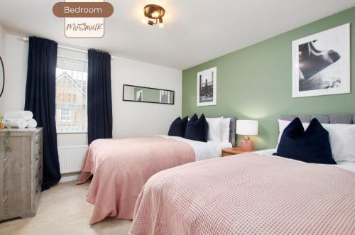 a bedroom with two beds with pink and white sheets at Spacious, 3BR, Coventry House | Sleeps 9 | Parking in Canley