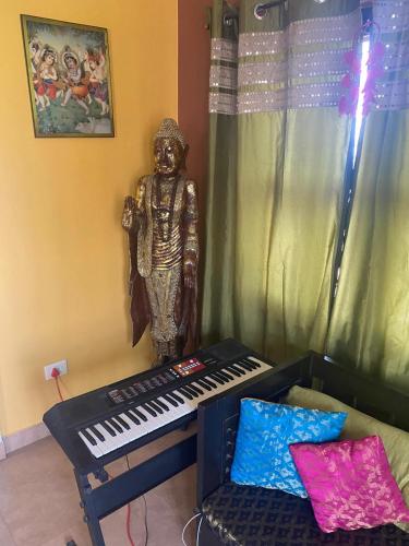 a statue sitting next to a piano next to a statue at Krishna Divine 2 Bedroom Home in mayapur