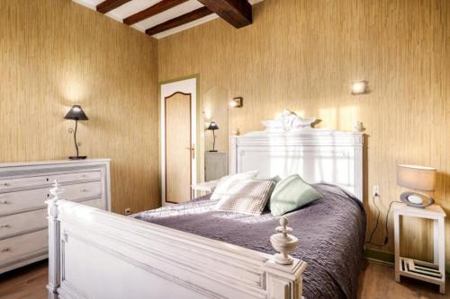 a bedroom with a large white bed and a mirror at Gîte du Gros Hêtre in Sainte-Beuve-en-Rivière