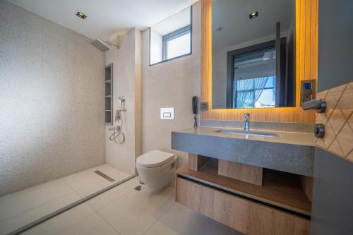 a bathroom with a sink and a toilet and a mirror at Batıhan Vadi Hotel in Kusadası
