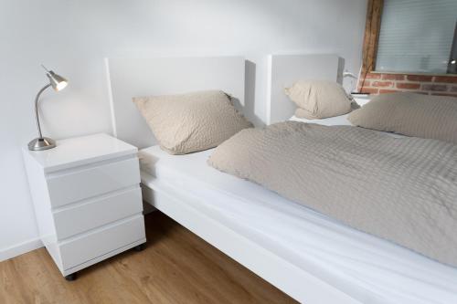 a bedroom with a white bed and a night stand at Kara Ben Nemsi in Ilmmünster