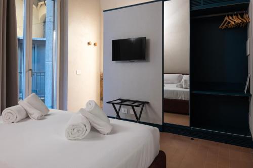 a bedroom with two beds and a tv on a wall at Dal Console Rooms in Naples