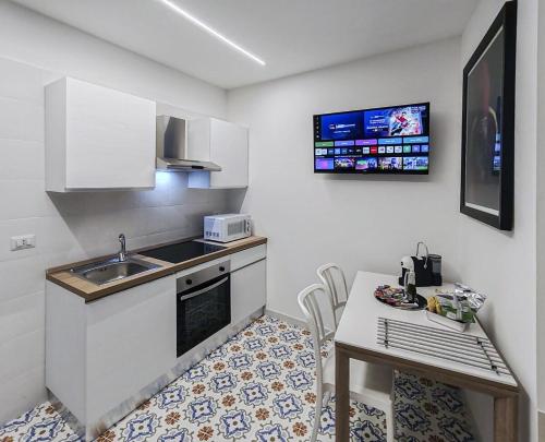 a small kitchen with a sink and a table at Casa Del Duca in Salerno