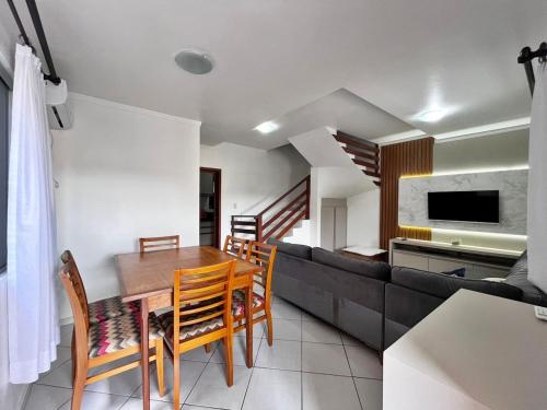 a living room with a dining table and a couch at Casa ampla e confortável em Balneário Camboriú in Balneário Camboriú