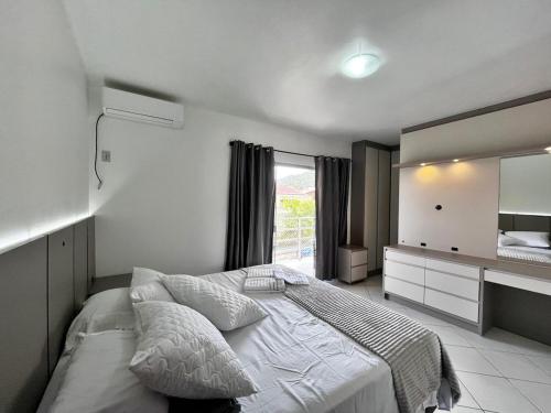 a bedroom with a bed and a large mirror at Casa ampla e confortável em Balneário Camboriú in Balneário Camboriú