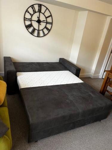 a bedroom with a bed and a clock on the wall at 2 The Grove in Coalbrookdale