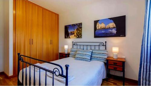 ein Schlafzimmer mit einem Bett mit zwei Nachttischen und zwei Lampen in der Unterkunft Charming Orada 2-Bedroom Albufeira Duplex Apartment with Shared Pool sleeps 6 in Páteo