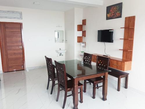 ein Esszimmer mit Tisch und Stühlen und einem Fernseher in der Unterkunft Le Sasvik in Kodaikanal
