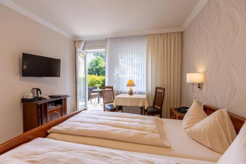 ein Hotelzimmer mit einem Bett und einem Tisch mit Stühlen in der Unterkunft Hotel-Garni Haus Johanna in Einbeck