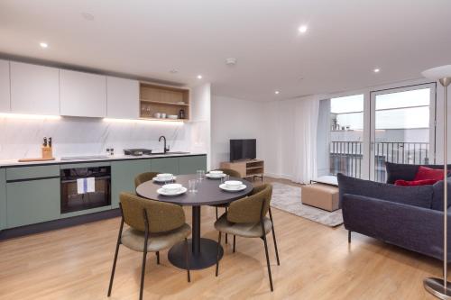 a kitchen and a living room with a table and chairs at Orchard by UTDM in Bristol