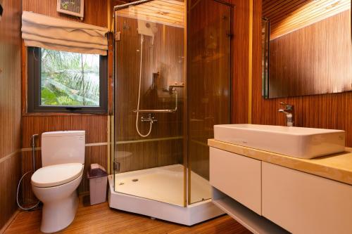 ein Badezimmer mit Toilette, Dusche und Waschbecken in der Unterkunft Sim Resort in Phu Quoc