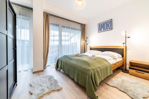 ein Schlafzimmer mit einem Bett und einem Flachbildfernseher in der Unterkunft Tisza Terrace Apartman by Mital in Szeged