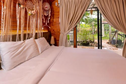 Schlafzimmer mit einem großen weißen Bett mit Vorhängen in der Unterkunft Sim Resort in Phu Quoc