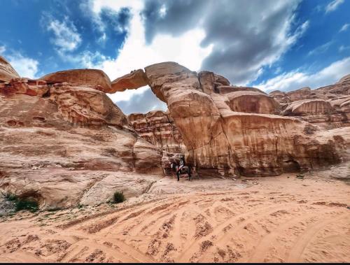 Un grupo de personas de pie frente a un arco. en Rum Laura luxury camp, en Wadi Rum