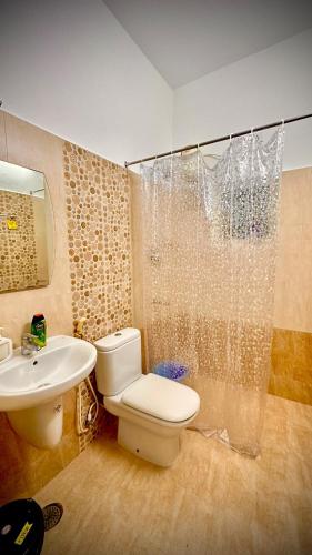 a bathroom with a toilet and a sink and a shower at Villa 25 Eat-Sleep-Beach-Repeat in Kilpettai