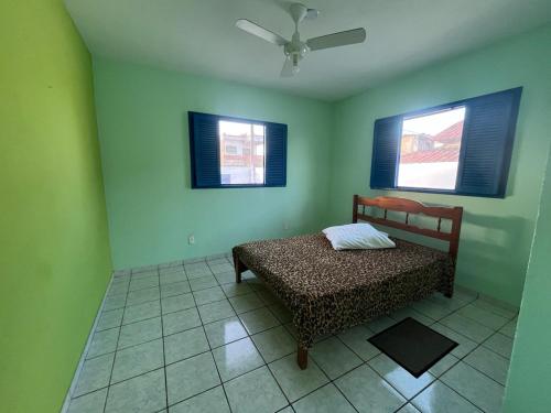 Un dormitorio con una cama y dos ventanas en Casa vista Mar, pé na areia com piscina !, en Pitimbu