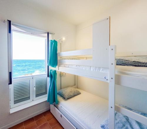 a bedroom with bunk beds with a view of the ocean at Las Eras Nest Hostel in Las Eras