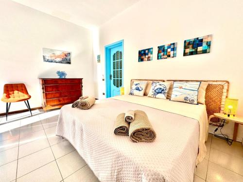 a bedroom with a bed with towels on it at Dipinto di Blu - Faraglioni Seaside Retreat in Aci Castello