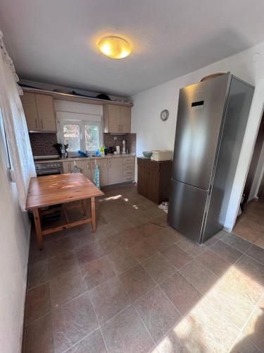 eine Küche mit einem Kühlschrank aus Edelstahl und einem Tisch in der Unterkunft claudistaudis guesthouse in Vergia