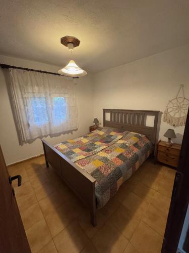 ein Schlafzimmer mit einem Bett mit einer Steppdecke darauf in der Unterkunft claudistaudis guesthouse in Vergia