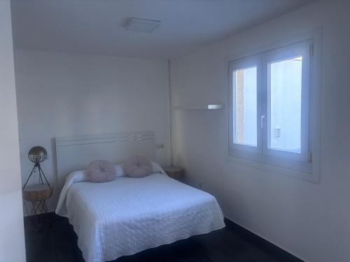 a white bedroom with a bed and a window at Luxe Loma 2 in Mogán