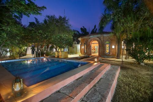 a swimming pool in the yard of a house at Tigergarh Wildlife Resort in Tāla