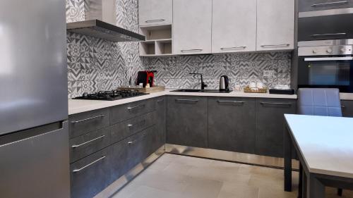 eine Küche mit weißen Schränken und einem Herd mit Backofen in der Unterkunft Villa Neviera Wine Resort & Spa by Cantine Due Palme in Cellino San Marco