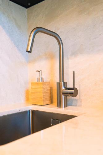 a kitchen sink with a faucet and a wooden block at Family Double floor top view Art Apartment R3&5 in The Hague