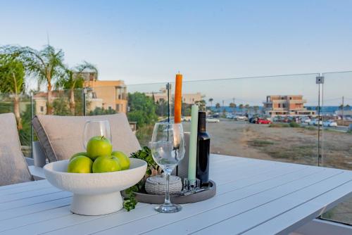une table avec un bol de fruits et une bouteille de vin dans l'établissement TelMar SeaView, à Oroklini
