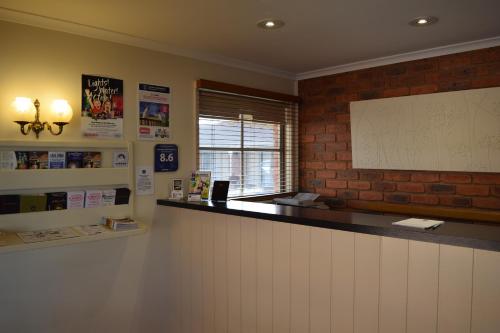 a bar in a room with a brick wall at Australian Settlers Motor Inn in Swan Hill